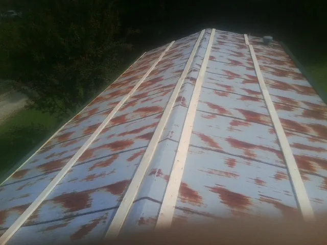 Rusted metal roof panels with new wood purlins before replacement — Storm Damage Roof Repair in Tillson by Roofing Brothers