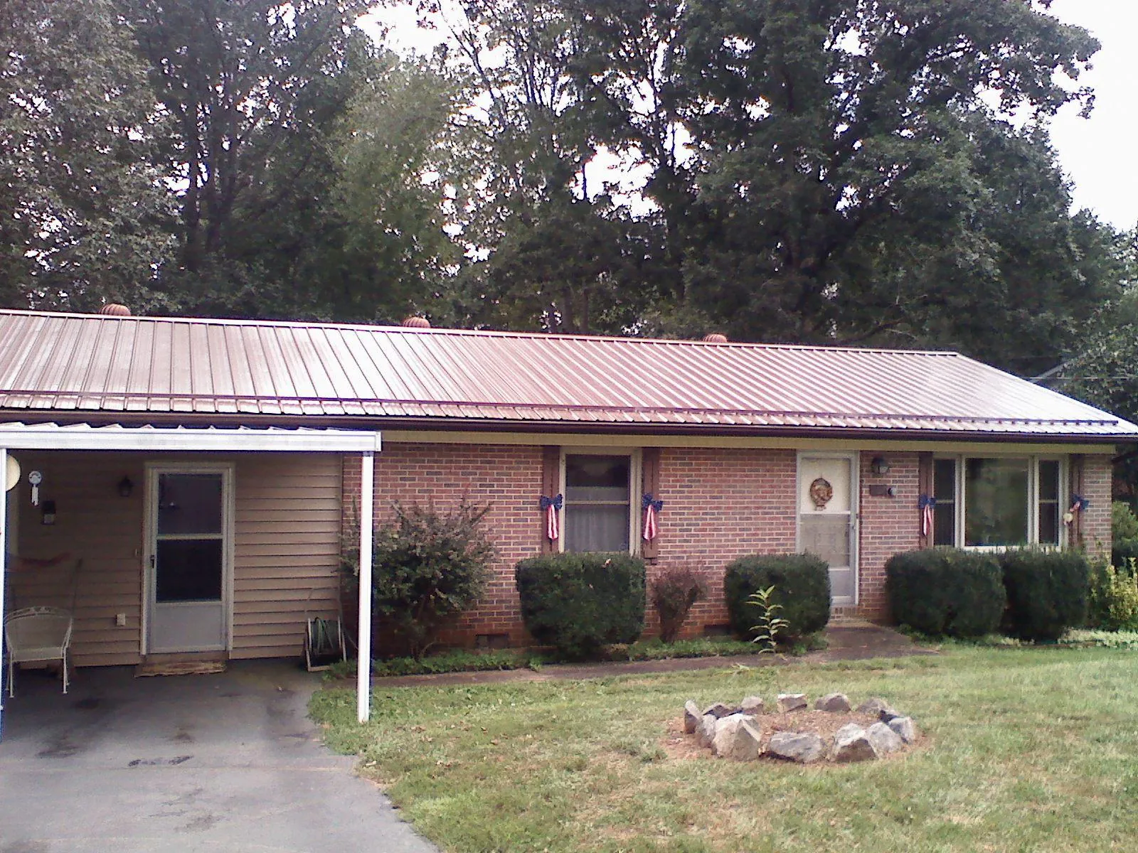 Bronze metal roof and carport on a brick ranch home — Roof Repair work by our crew in Tillson